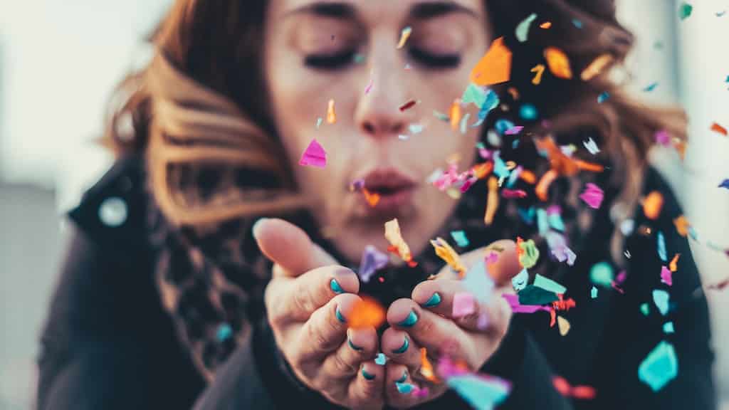 girl blowing confetti