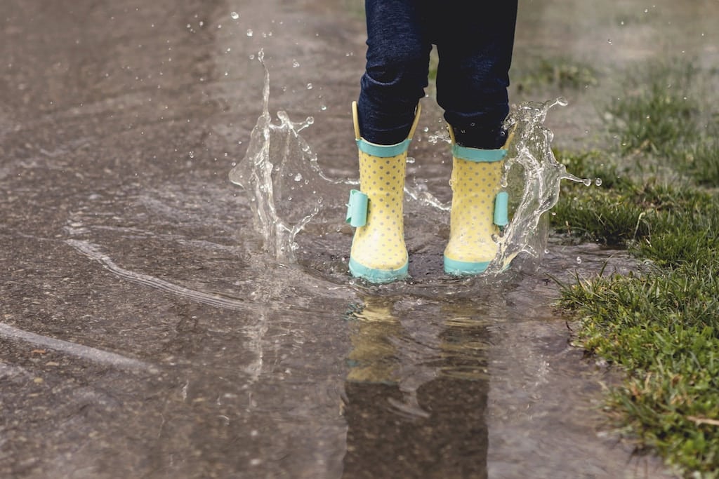 child playing in puddle